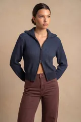 Campera de punto azul oscuro, de calce al cuerpo, con textura acanalada, cuello solapa y cierre frontal completo con cremallera.