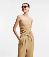 Blusa cropped color beige, de sastrería, con escote sin breteles y lastex en la espalda.