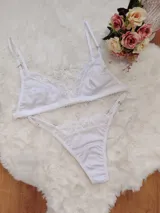 Conjunto de lencería compuesto por un corpiño triangular y una bombacha tipo colaless, ambos confeccionados en algodón blanco con detalles de encaje en los bordes.