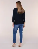 Remera negra de silueta recta y escote redondo, confeccionada en algodón y elastano. Presenta mangas tres cuartos y apliques de guipure calado en los laterales del ruedo.