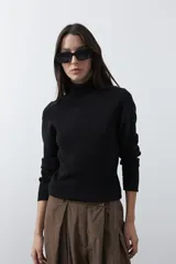 Polera de manga larga y cuello alto, confeccionada en tejido de punto fino, con un ajuste ceñido al cuerpo.