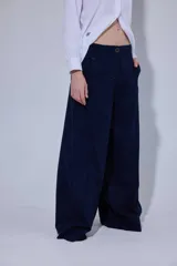 Pantalón de corte ancho y tiro medio, confeccionado en una mezcla de lino y algodón. Presenta cierre frontal con botón, dos bolsillos laterales y dos bolsillos traseros con detalles de remaches.