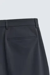 Pantalón de traje regular fit negro, confeccionado en tejido técnico transpirable Non Iron, con bolsillos frontales, bolsillos traseros de vivo y cierre frontal con cremallera y botón.