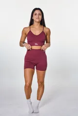 Conjunto deportivo compuesto por un top de breteles finos con logo estampado y un short de tiro alto, ambos en tejido de punto acanalado color bordó.