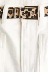 Jean de tiro alto en denim de algodón blanco, con corte de pierna recta, bolsillos delanteros tipo parche y pliegues marcados. Incluye un cinturón estampado con diseño animal print de leopardo.