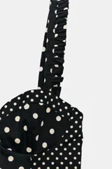 Top estilo corset con escote corazón, tirantes anchos con detalle de fruncido y cierre posterior con cremallera. Presenta un diseño de estampado de lunares en contraste.
