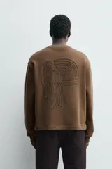 Sudadera de corte boxy fit, color marrón, con cuello redondo y manga larga. Presenta acabados en rib en puños y ruedo.