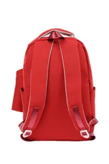 Mochila escolar de tela color azul claro, con múltiples compartimentos con cierre, bolsillo frontal con cierre y un pequeño accesorio colgante cilíndrico a juego. Presenta un parche circular con un emoji sonriente en el frente.