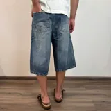 Bermuda de jean negro con corte ancho y largo a la rodilla.