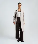 Saco largo de corte recto confeccionado en polivelour, con cuello de solapas, cierre frontal con botones y bolsillos laterales. Presenta un diseño elegante y funcional, ideal para la temporada de invierno.