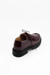 Zapatos tipo wallabee de cuero metalizado en tono peltre, con cordones negros y suela track de goma negra con plataforma.