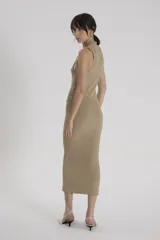 Vestido largo color beige, sin mangas y cuello alto. Tejido de punto ultradelgado y translúcido con lurex metalizado.