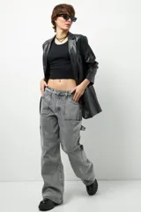 Jean de corte carpenter, estilo wide leg y tiro bajo, en color gris lavado. Presenta diseño de bolsillos frontales tipo parche y costuras reforzadas.