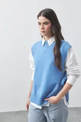 Chaleco tejido de punto con silueta relajada y diseño sin mangas. Presenta lazos laterales ajustables y cuello redondo.