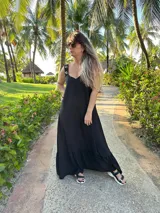 Vestido largo fucsia con breteles finos y detalle de tachas doradas en los breteles.