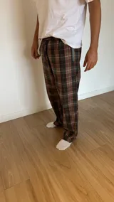 Pantalón de hombre confeccionado en franela a cuadros grises y marrones, con elástico en la cintura y dos bolsillos laterales.