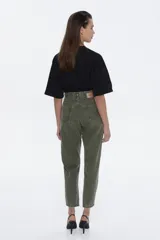 Pantalón de jean de tiro alto, color verde oliva desgastado, con calce relajado y piernas que se afinar hacia el tobillo.