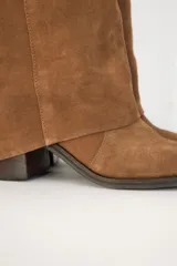 Bota de caña alta de gamuza color marrón, con diseño volcado y taco cuadrado.