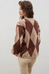 Buzo de punto con diseño de rombos en tonos azul y marrón, con cuello redondo y mangas largas.