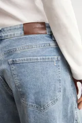 Jean wide leg de tiro medio con diseño bicolor, confeccionado en denim de lavado celeste con detalles de costuras y paneles en contraste. Cuenta con botamanga desflecada.