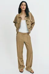Pantalón recto de tiro bajo en color verde militar, con nervios marcados en la parte delantera, bolsillos frontales y cierre con cremallera, botón interior y ganchos.