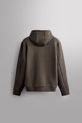 Campera canguro de Zara Athleticz, modelo relaxed fit, confeccionada en tejido técnico compacto elástico con mezcla de algodón en color azul marino. Cuenta con cuello subido con capucha, manga larga con bolsillo lateral con cierre, bolsillos frontales con cierre y acabado termofijado, cierre frontal de doble dirección y logo estampado en el bajo.