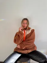 Canguro de polar color marrón chocolate con detalles en blanco y naranja.