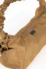 Cartera de hombro Daniel Cassin modelo Orren, de color verde seco. Cuenta con diseño fruncido en el asa, bolsillos laterales con cordón ajustable y cierre superior.