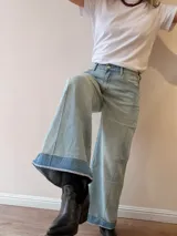 Pantalón jeans tipo palazzo de corte amplio y tiro medio-alto, con lavado celeste vintage y dobladillo vuelto con detalle de rayas en la terminación. Cuenta con bolsillos delanteros y traseros.