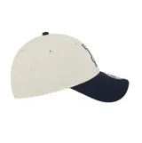 Gorra New Era 9FORTY de Los Angeles Dodgers, color beige con visera y botón superior en azul marino, con el logo del equipo bordado en el frente.