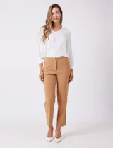 Pantalón sastrero slim color beige, de tiro alto con pretina anatómica y pinzas verticales en el frente. Cierre oculto y bolsillos laterales inclinados. Largo al tobillo.