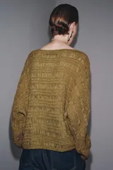 Jersey de punto con cuello barco y manga larga, color dorado/mostaza, con textura acanalada y efecto arrugado.