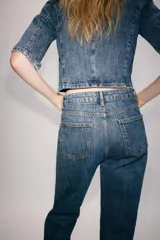 Jeans flare de tiro alto de Zara Woman Collection, en color azul con efecto lavado. Presentan un corte slim en la parte superior y perneras acampanadas con raya planchada al frente y dobladillo ancho. Incluyen cierre frontal con cremallera y botón.