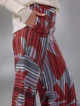 Pantalón de cintura alta y piernas amplias en lino mezcla, con estampado vegetal en tonos bordó, gris y blanco, y tajos asimétricos en las piernas. Cuenta con cierre invisible lateral y bolsillos.