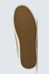 Zapatilla de cordones color negro con parte superior lisa, horma redonda y forro interior a contraste. Suela de goma color crema con ligera textura y detalle en el talón color crema.