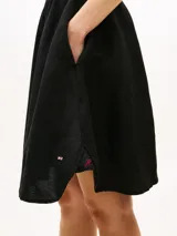 Vestido camisero corto negro confeccionado en mezcla de lino y viscosa, con cuello en V, manga tipo kimono, bolsillos con solapa en el pecho y cintura fruncida con cinturón incorporado con hebilla dorada.