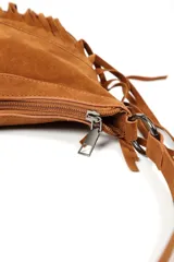 Cartera de gamuza negra con diseño de flecos largos en la parte inferior y detalle de hebilla metálica estilo western en el centro. Cuenta con correa larga ajustable para llevar al hombro o cruzada.