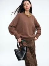 Sweater de tejido de punto en color rosa claro con motas de colores, de corte holgado, cuello redondo y mangas largas con hombros caídos.