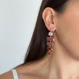 Caravanas colgantes de diseño lineal compuestas por una serie de piedras naturales de diversas formas y colores engarzadas en metal dorado.