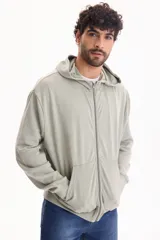 Campera con capucha y cierre frontal, color beige con efecto lavado stone wash, bolsillos tipo canguro y corte oversize.
