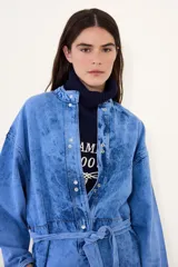 Mameluco de jean con efecto nevado estilo vintage, de corte holgado, mangas largas, cierre frontal con botones a presión y lazo ajustable en la cintura.