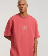 Remera relaxed de malla color salmón, con cuello redondo y mangas cortas. Estampa frontal y trasera con la palabra "EXPLR" dentro de un círculo.