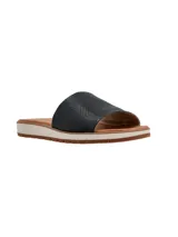 Sandalias planas con tira ancha en el empeine con textura símil reptil en color negro, plantilla marrón y suela bicolor con base dentada.