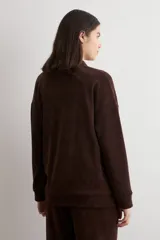 Sweater de tejido acanalado color marrón, con cuello alto y cierre frontal parcial. Presenta un diseño holgado de manga larga con hombros caídos.