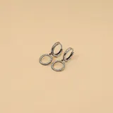 Aros tipo argolla con dije circular colgante, elaborados en plata 925 con engaste de circonias brillantes.