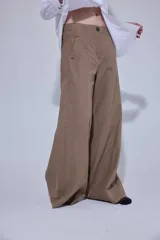 Pantalón de tiro medio y corte ancho, confeccionado en una mezcla de lino y algodón. Presenta bolsillos delanteros y traseros con detalles de remaches y costuras reforzadas.