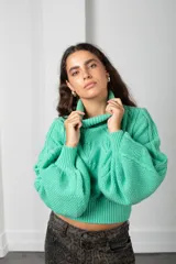 Polera de tejido de punto color verde menta, con cuello alto, mangas largas abullonadas y puños y cintura acanalados.