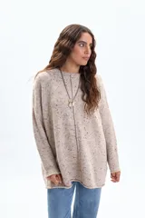 Buzo oversize de tejido de punto en color tostado con efecto jaspeado. Presenta un diseño de corte holgado, cuello redondo y un detalle de costura central vertical (nervio) en el frente.