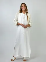 Vestido largo blanco de lino con mangas tres cuartos de crochet, cuello mao y abertura frontal con cordones.