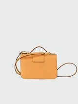 Cartera crossbody Longchamp modelo Box-Trot XS, color amarillo, con solapa frontal, cierre metálico con logo y correa ajustable.